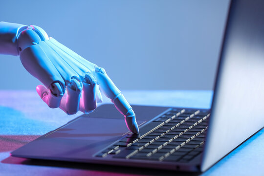Artificial intelligence. Robot hand using laptop on table in neon lights, closeup