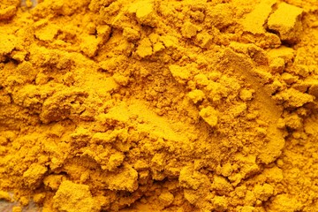 Heap of turmeric powder on table, top view