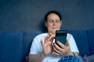 a senior woman chatting on the phone in bed