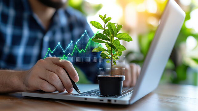 close up of analyst working on laptop with small plant, symbolizing green economy growth and sustainability. digital graph overlay represents data analysis