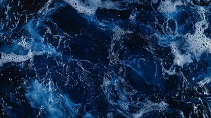 Dark blue ocean water with white foam texture.