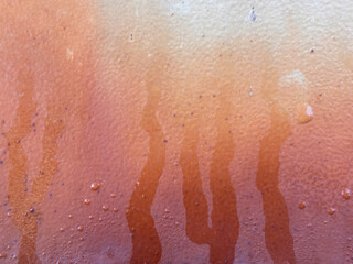 Fototapeta premium A wall with a brownish orange paint that has drips on it