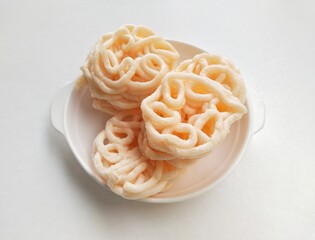 High angle view of Palembang fish crackers in a white plate on a white background. 