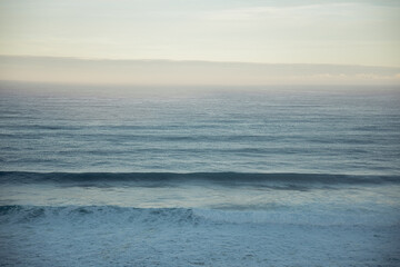 Obraz premium Sea horizon and gentle sky at sunrise with rolling waves