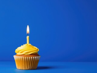 A golden yellow cupcake adorned with a flame-emitting candle standing out against a deep blue backdrop, celebration treats, , party themed food