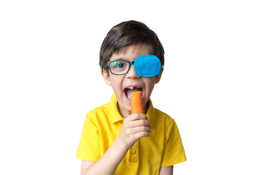 Boy in glasses with eye patch with a carrot. Occluder, lazyeye, amblyopia, strabismus. Vision testing concept. Reviewing eyesight
