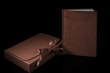 Best gift for men. Man gift concept. Red notebook with red gift box on black background. Copy space. Valentine's day, wedding, birthday and special occasion gift concept. Copy space for text.