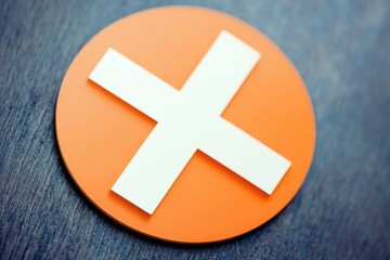 Obraz premium A simple orange button with a white medical cross icon