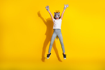 Preteen girl in cosplay wolf mask posing playfully against a bright yellow background