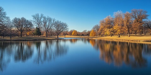 Serene lake in a park showcasing reflections of trees during winter, spring, or late fall, highlighting the tranquil beauty of the season reflected in the lake s calm surface.