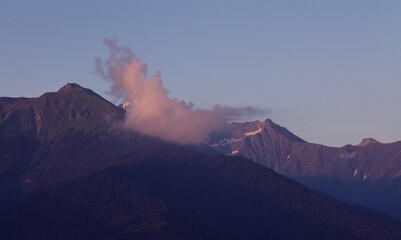 Majestic mountain peaks capped with snow and washed by clouds create a breathtaking wilderness...