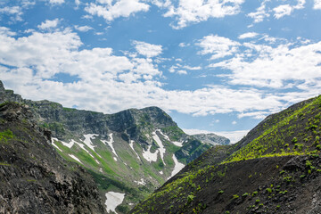 Green mountains, shrouded in clouds and fog, create a mysterious atmosphere and a fascinating view of nature
