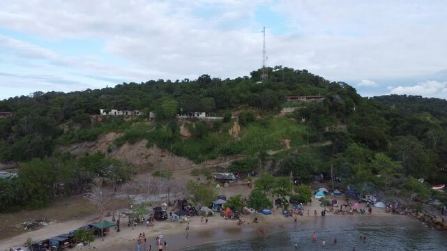 Aerial view of Chuspa, Venezuela &ndash; Coastal fishing village surrounded by lush green mountains and tropical forest, beach shoreline and calm sea, beautiful natural landscape