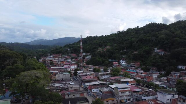 Aerial view of Chuspa, Venezuela &ndash; Coastal fishing village surrounded by lush green mountains and tropical forest, beach shoreline and calm sea, beautiful natural landscape