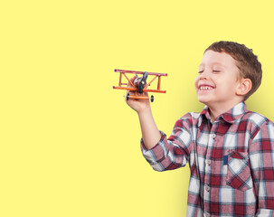 A joyful boy with a smiling face holds an airplane, personifying a childhood dream of adventure and...