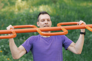 Man completing pull-ups on monkey bars in park setting