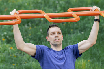 Athlete performing pull-ups on monkey bar outdoors