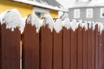 red board fence with snow in a Latvian city
