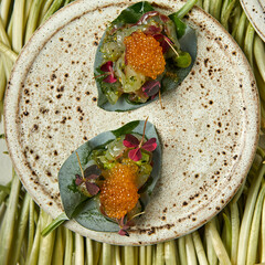 bruschetta in the form of red caviar laid out on greenery