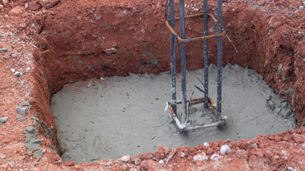 Closeup of rebar tied with wire into a fence post structure. Set in a hole that has already been poured in. Copy space