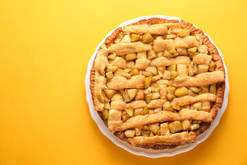 Tasty homemade apple pie on yellow background, top view. Space for text
