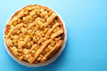 Tasty homemade apple pie on light blue wooden table, top view. Space for text