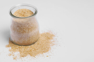 Oat bran in glass jar on white background