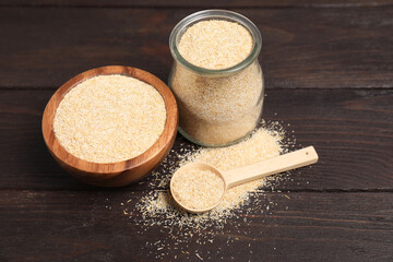 Oat bran in glass jar, bowl and spoon on wooden table