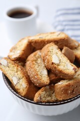 Traditional Italian almond biscuits (Cantucci) in bowl on white table, closeup