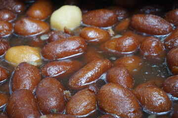 Popular Bangladeshi dessert Gulab Jamun with sugar syrup, Traditional Bangladeshi sweet called rasgulla or rasgoola is being sold at a market, Gulab jamun and rasgulla are displayed together