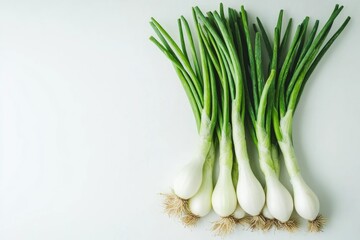 Bunch of green onions are displayed on a white background. The onions are fresh and ready to be used in a meal