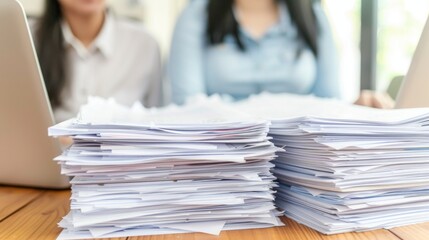 Two friends engaged in a deep conversation at a wooden table with research papers and laptops, soft blurred background.