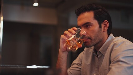 Sitting smart man drinking alone of cocktail Old fashioned waiting friends or couple at bokeh lighting at luxurious beverage counter nightclub at pub and restaurant on Friday meeting night. Vinosity.