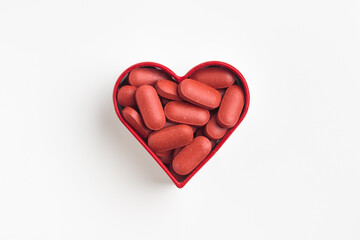 The heart made of red pills on a white background. Medicinal pills and capsules for health, dietary...