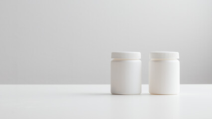 White plastic medicine bottles on a white background with copy space. Medicine and health concepts include a jar with pills or vitamins. High-quality photo banner