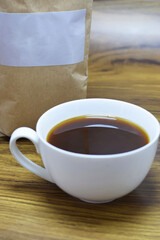 Taza de café y empaque en grano, bolsa para café con espacio para texto. Toma a detalle.
