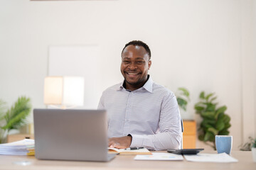 African American businessman working with laptop Take notes on documents in the office and prepare...