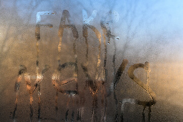 fake news inscription on the wet glass of the showcase.