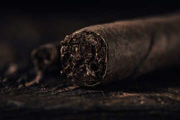 Cigar on dark wooden background. Selective focus. Toned.