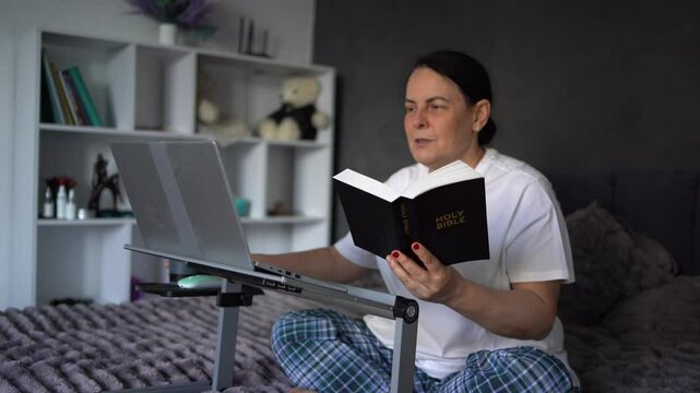       senior woman attends online church, video conference with priest