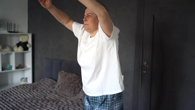     senior woman performs somatic exercises, yoga at home