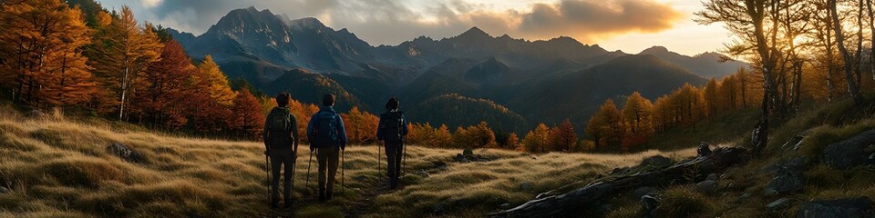 Obraz premium Wide shot of hikers walking along a trail lined with vibrant autumn trees, with the rugged Hotaka peaks glowing under the fiery hues of sunset, in 4K resolution