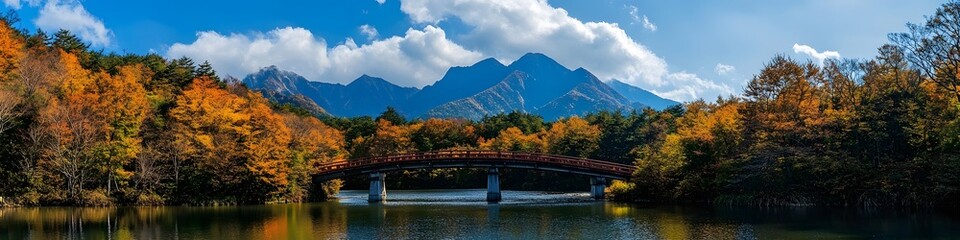 Wide-angle shot of the Kappa Bridge framed by vibrant summer foliage, with the majestic Hotaka Mountain Range in the background, in 4K resolution