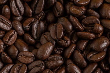 Aromatic Roasted Coffee Beans Textured Background. Close-up of roasted coffee beans forming a textured background. Perfect for concepts related to coffee production, brewing, café culture