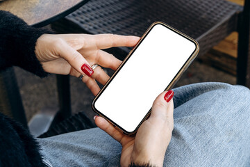 Mockup woman's hand holding using smart phone with white blank screen POV at coffee shop, mobile app design and advertising, online marketing
