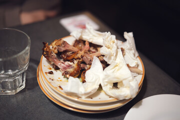 Crumpled used napkins and leftover food standing on a table in a restaurant