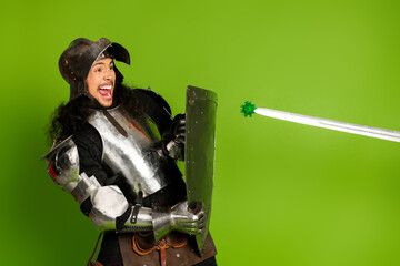 Naklejka premium Medieval knight in armor humorously defending against a symbolic virus on bright green background