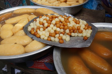 Popular Bangladeshi dessert Gulab Jamun with sugar syrup, Traditional Bangladeshi sweet called rasgulla or rasgoola is being sold at a market, Gulab jamun and rasgulla are displayed together