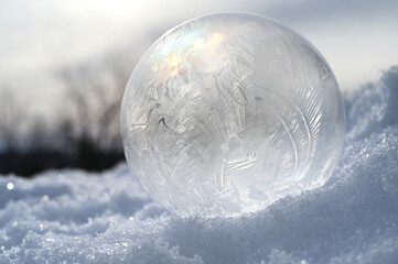 Frozen bubble on snow - cold winter background concept