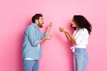 Young multiethnic couple arguing against pink background expressing emotions